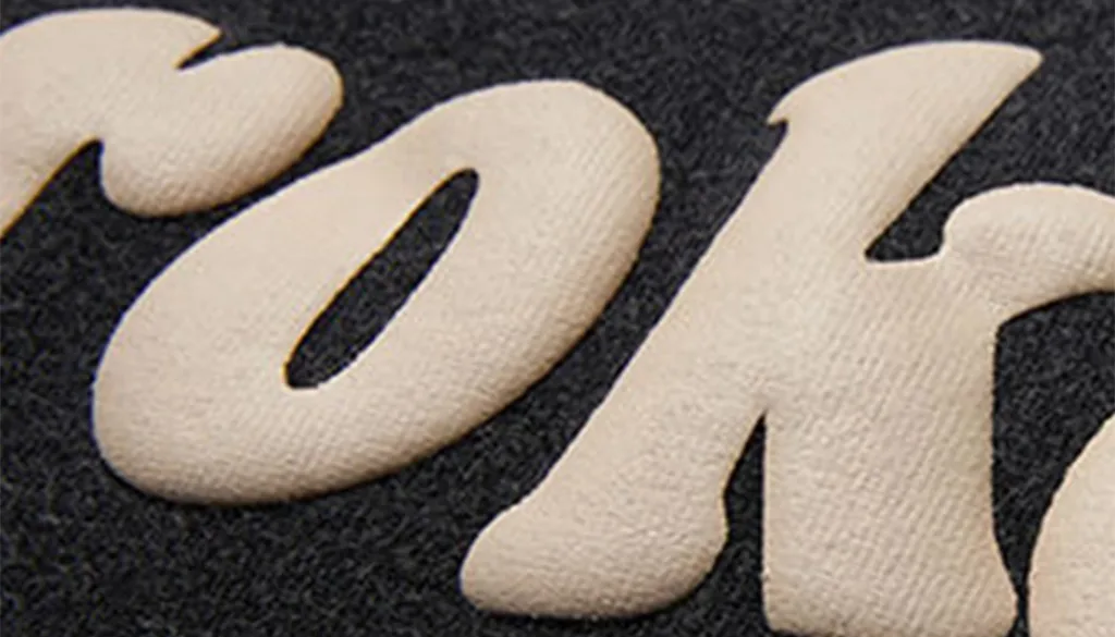 Stylish Puff Print Hoodies for Cozy Warmth and Trendy Look 2 Close-up of raised embroidered lettering on fabric.