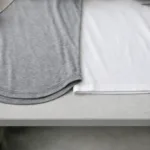 A professional top-down view showing a scoop rounded hem t-shirt next to a straight hem t-shirt. Details highlight the curvature and finishing of each hem for visual clarity.