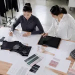 Gym clothing manufacturers use grading tables and digital tools to develop accurate size charts for international markets. The image showcases pattern development in a professional factory context.
